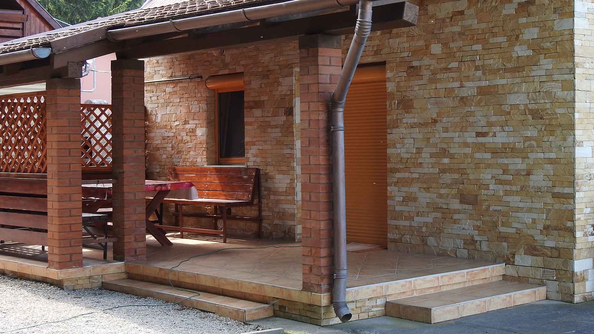 A képen a vendégház és a fedett terasza látható.